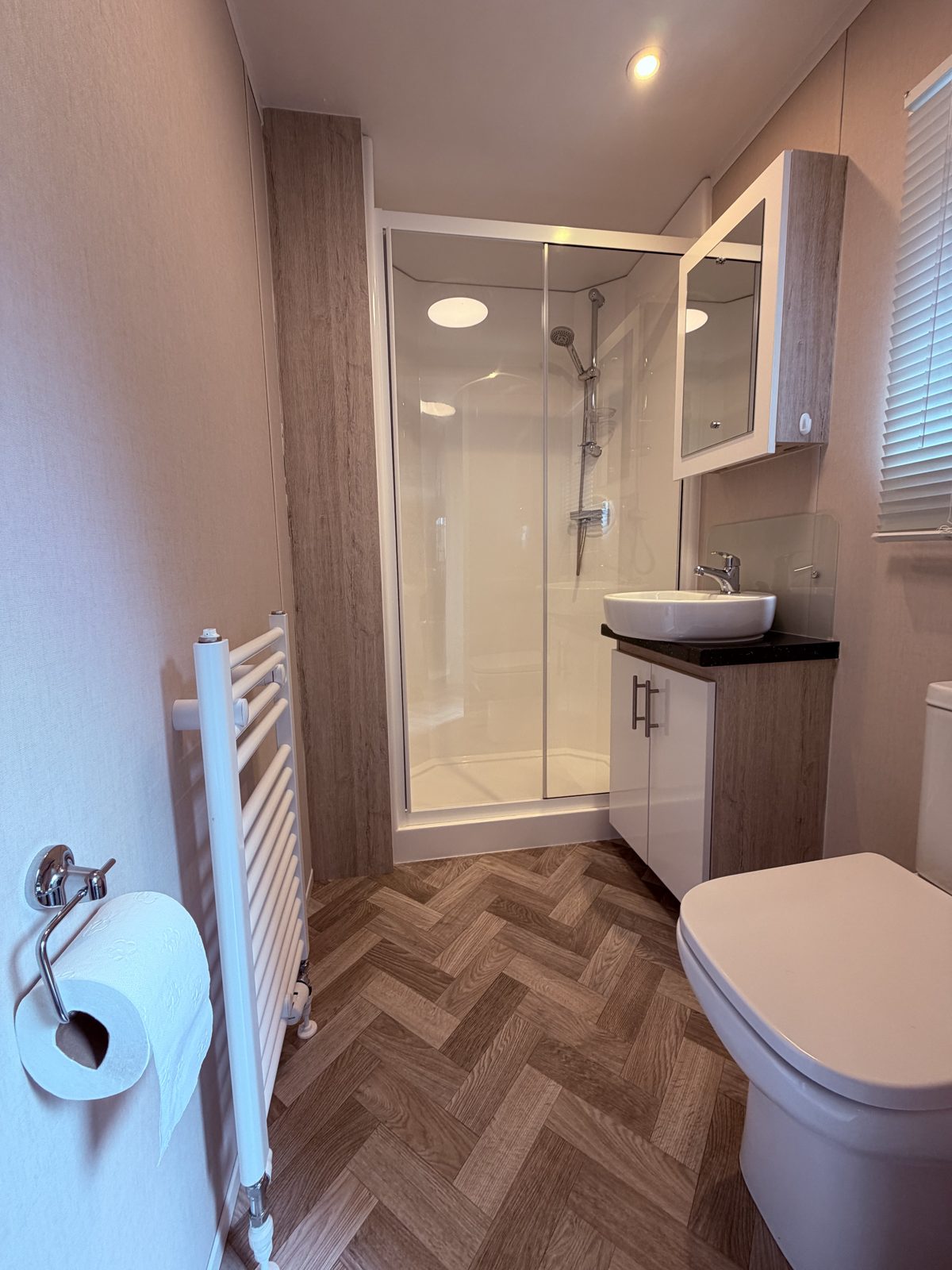Badezimmer mit Dusche, Waschbecken und WC